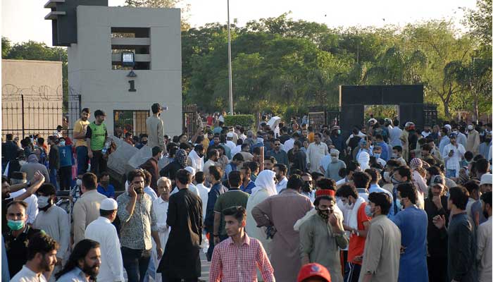 PTI workers and supporters gather in front of the main entrance of General Headquarters during a protest against Chairman Imran Khans arrest, in Rawalpindi on May 9, 2023. — AFP