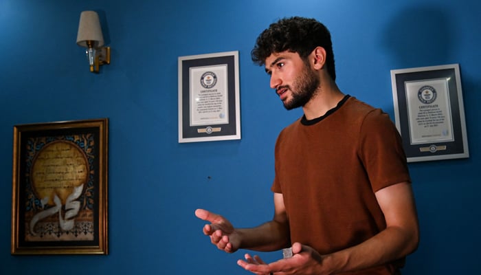 Mountaineer Shehroze Kashif speaks with AFP while standing next to his Guinness records certificates inside his home in Lahore.