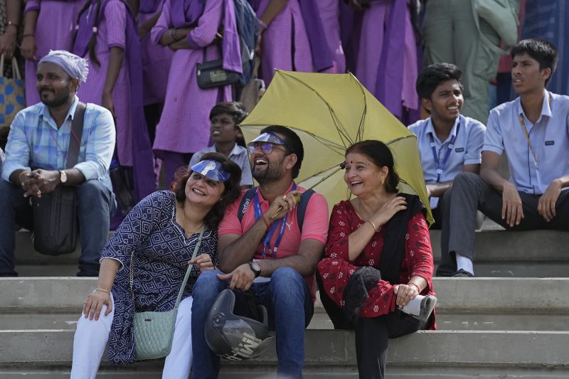 People listen to a live broadcast of scientists speaking after the launch of spacecraft Chandrayaan-3.