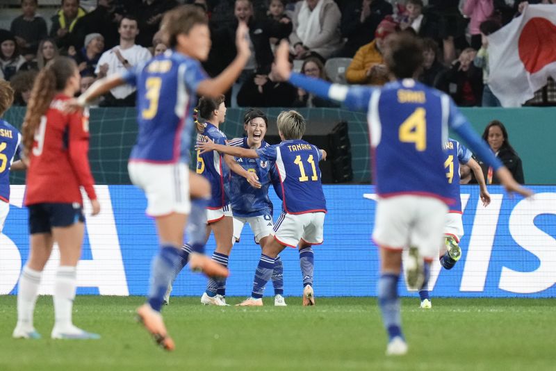 Japan's Hikaru Naomoto, center, celebrates with teammates after scoring the opening goal in the 2-0 victory over Costa Rica on July 26. It was Japan's second win in as many games, and it clinched a spot in the knockout stage.