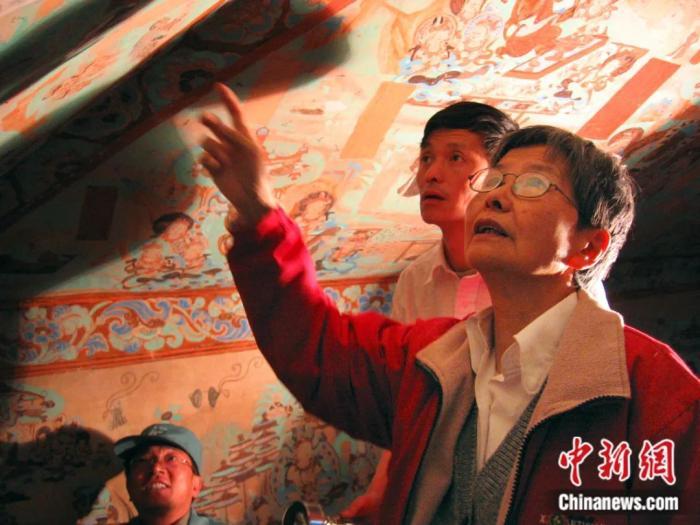 樊锦诗(右一)在莫高窟第85窟壁画修复现场。敦煌研究院供图