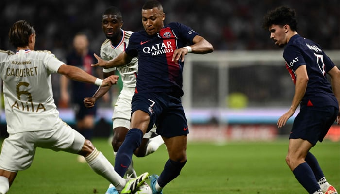 Lyons midfielder Maxence Caqueret (L) and Paris Saint-Germains Kylian Mbappe fight for the ball during the French L1 football match between Lyon and PSG at The Groupama Stadium in Decines-Charpieu, central-eastern France on September 3, 2023. — AFP