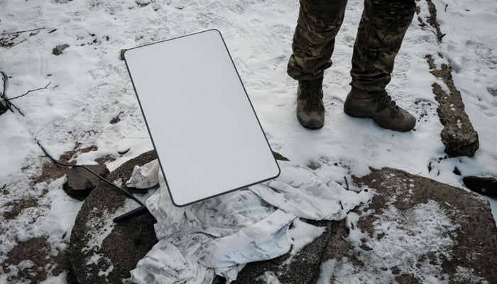 A Ukrainian serviceman stands next to the antenna of the Starlink satellite-based broadband system in Bakhmut on February 9, 2023. — AFP