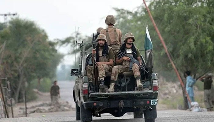 Armed security forces personnel ride on an army van. —AFP/