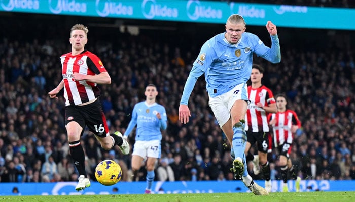 Erling Haaland tucks his shot away for the match-winning goal against Brentford. — AFP