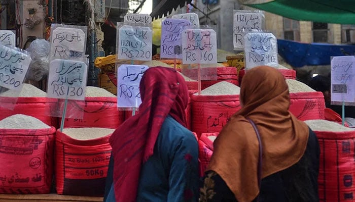 Women check rice prices at a wholesale market in Karachi in this picture taken on January 10, 2023. — AFP