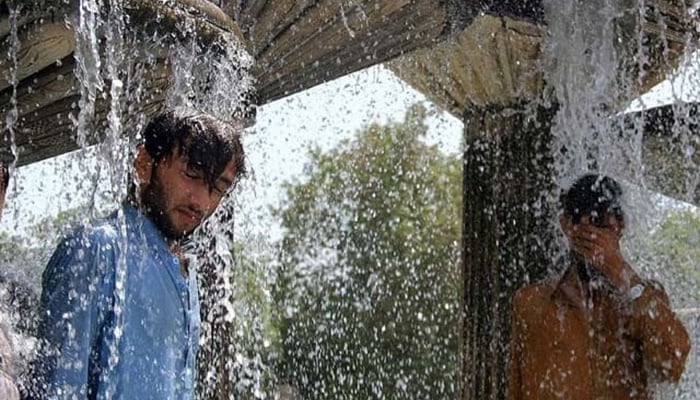 Karachiites cool off during an hot summer day in the metropolis. — AFP