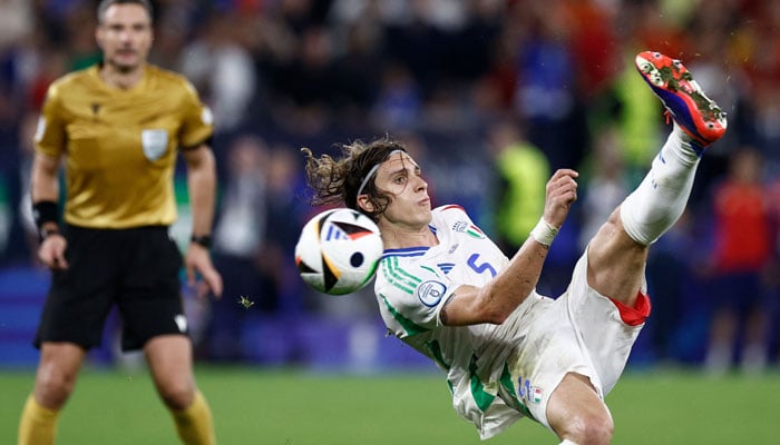 Italys defender #05 Riccardo Calafiori (R) kicks the ball and fails to score during the UEFA Euro 2024 Group B football match between Spain and Italy at the Arena AufSchalke in Gelsenkirchen on June 20, 2024. — AFP